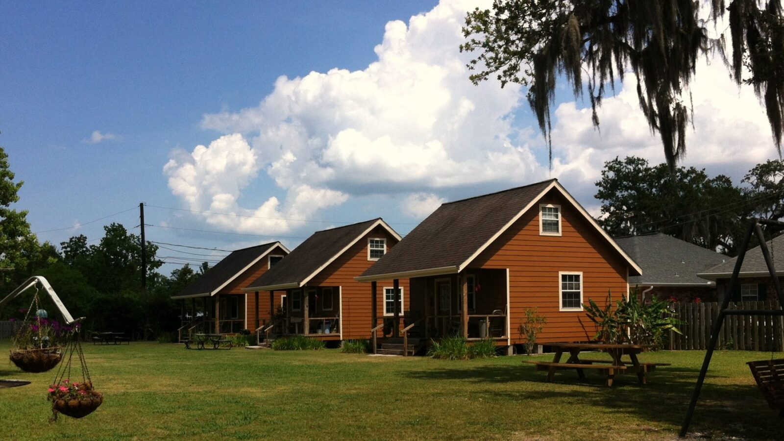 The three cabins with the lawn and swing in front