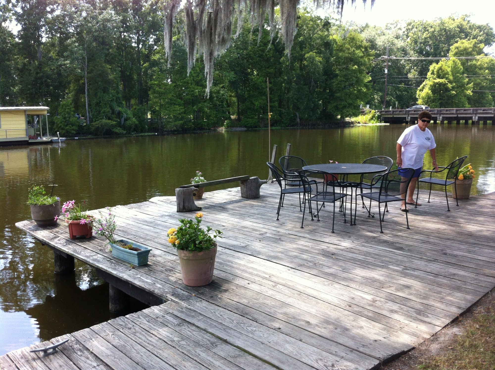 A table and chairs on the wharf over the bayou